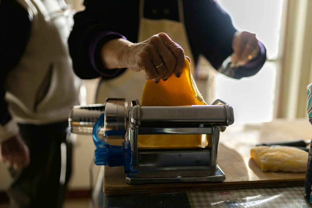 a person pouring orange juice into a blender